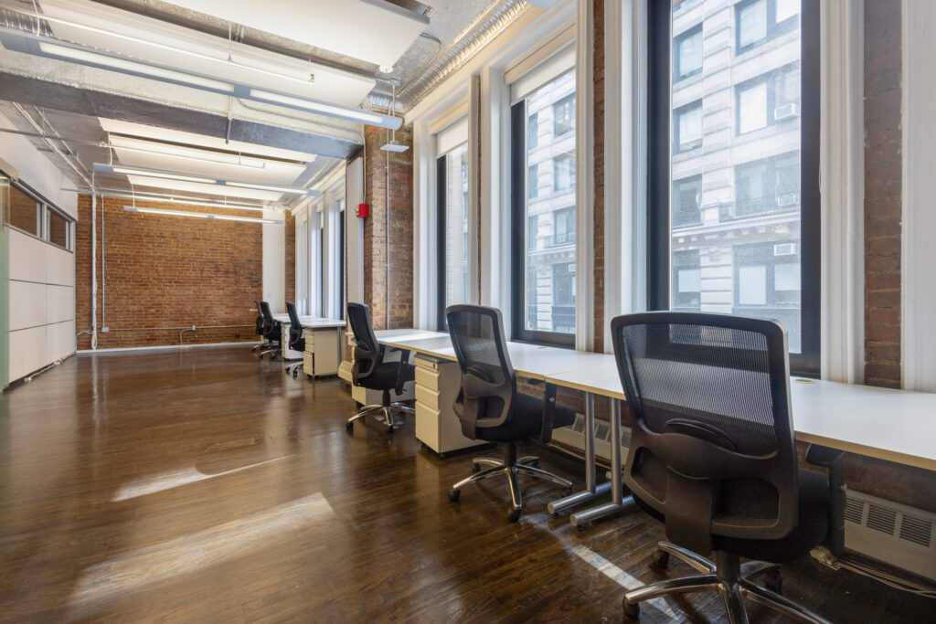 five coworking chairs and desks in front of a window at a coworking space in chelsea